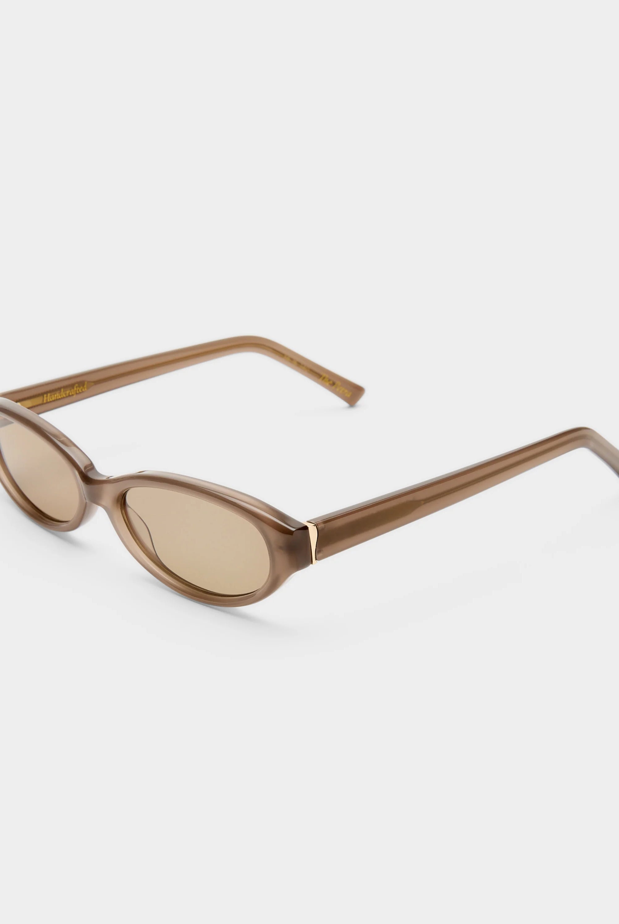 Brown sunglasses with a thin frame on a white background