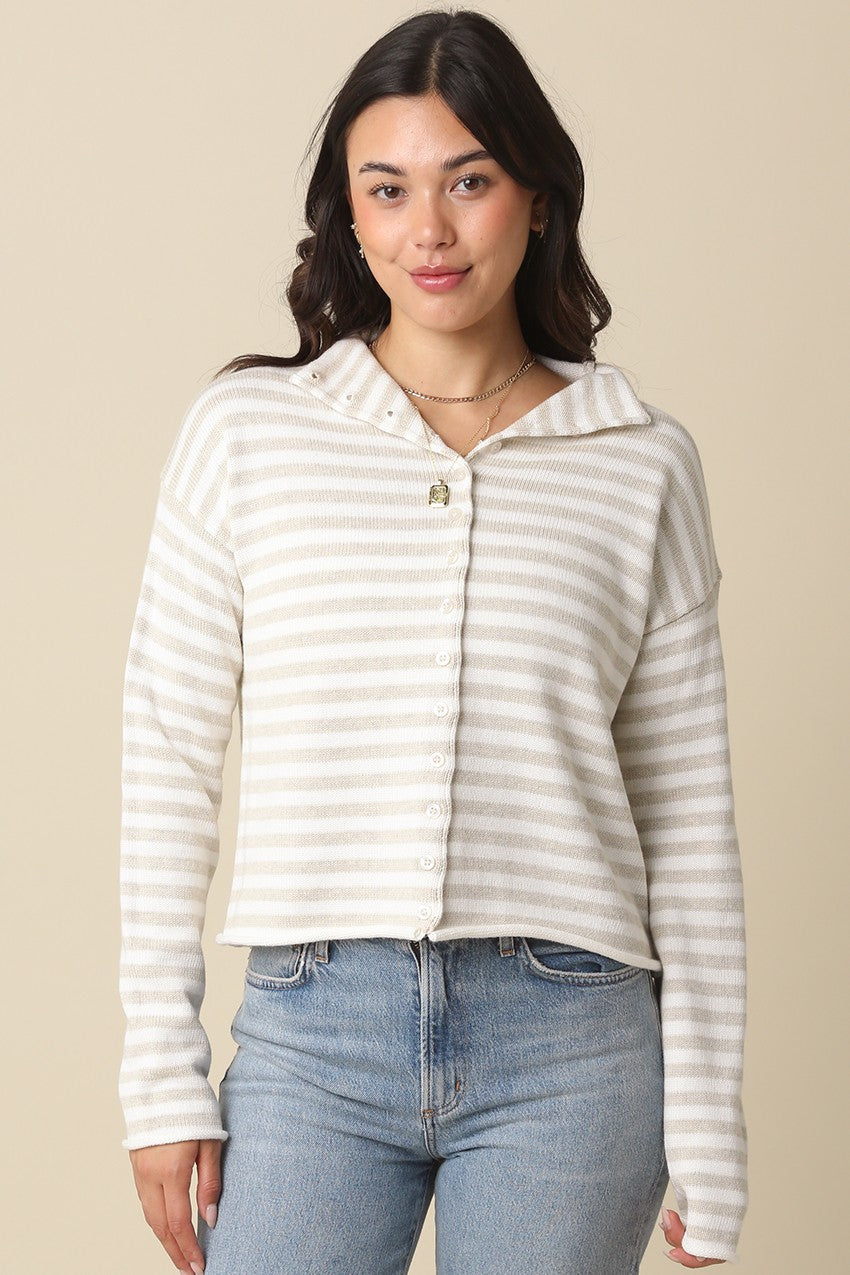 Woman wearing a striped shirt and jeans against a beige background