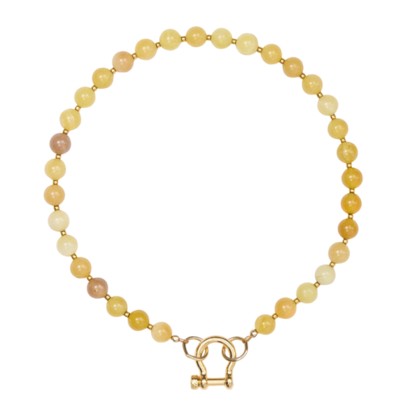 Necklace with yellow and beige beads and a gold clasp on a white background