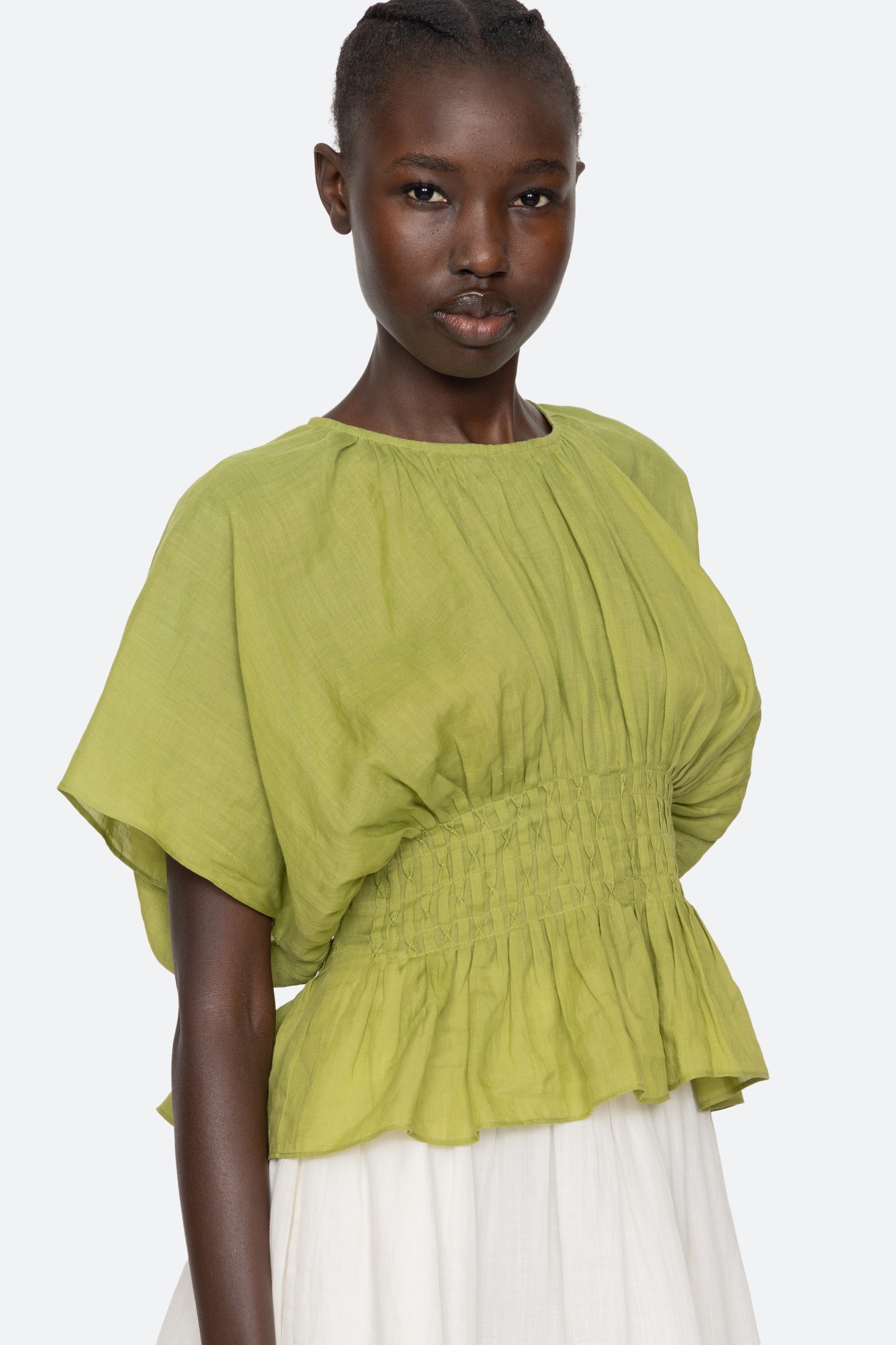 Woman wearing a green blouse with a plain background