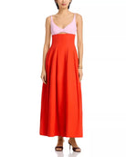 Woman wearing a two-tone dress with a pink top and red skirt on a white background