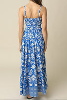 Woman wearing a blue floral dress against a beige background