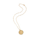 Gold necklace with a round pendant on a white background