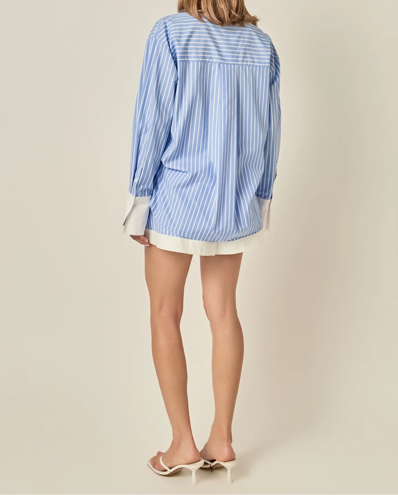 Woman wearing a blue and white striped shirt on a beige background
