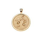 Gold pendant with floral design and engraved text on a white background