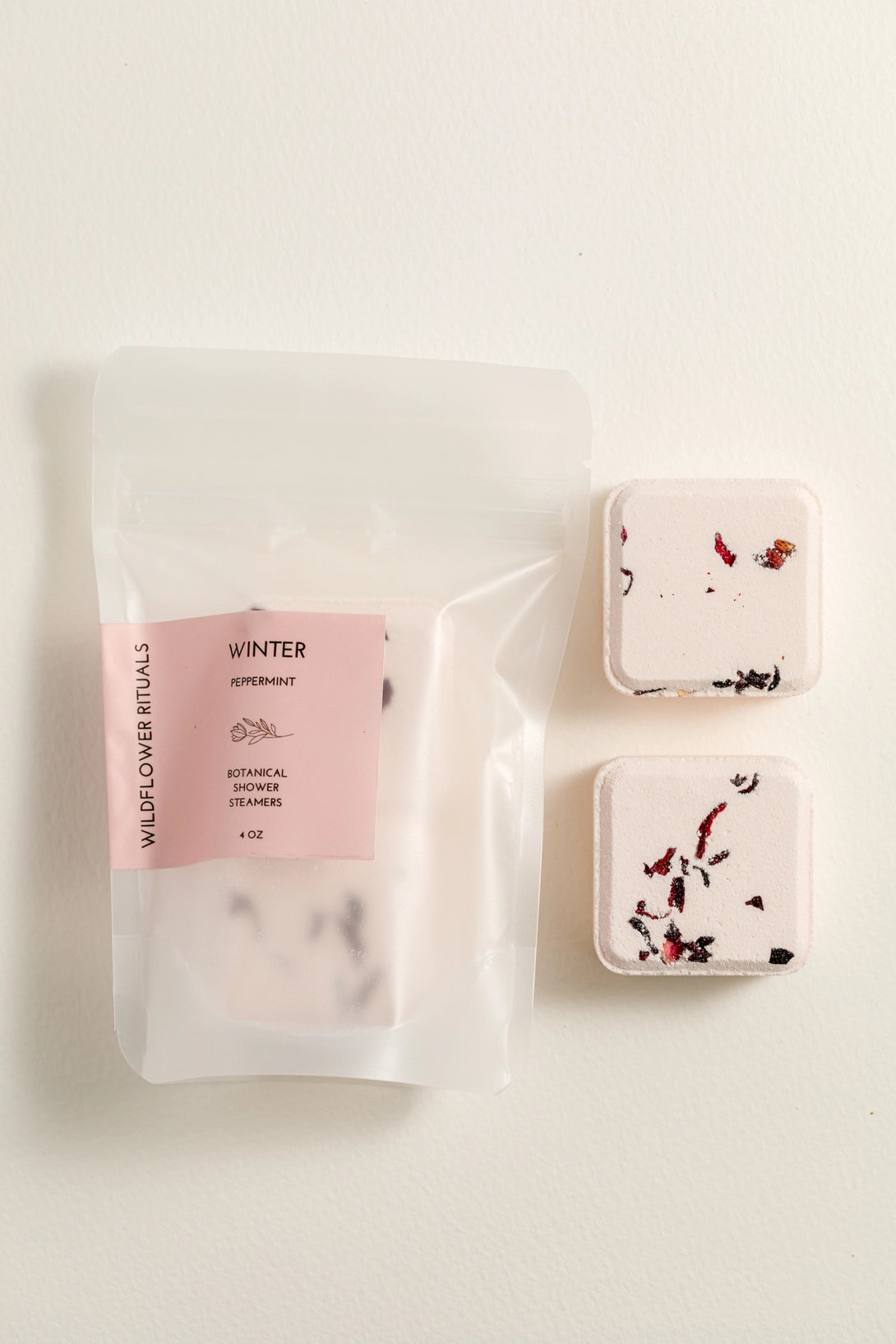 Two square containers with floral designs on a white background, next to a clear package labeled 'Winter'.