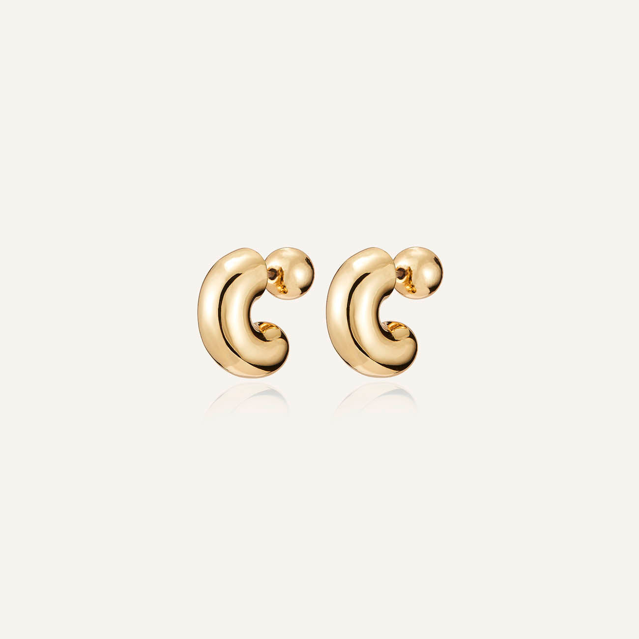 A pair of gold-colored hoop earrings with a high polish finish on a white background
