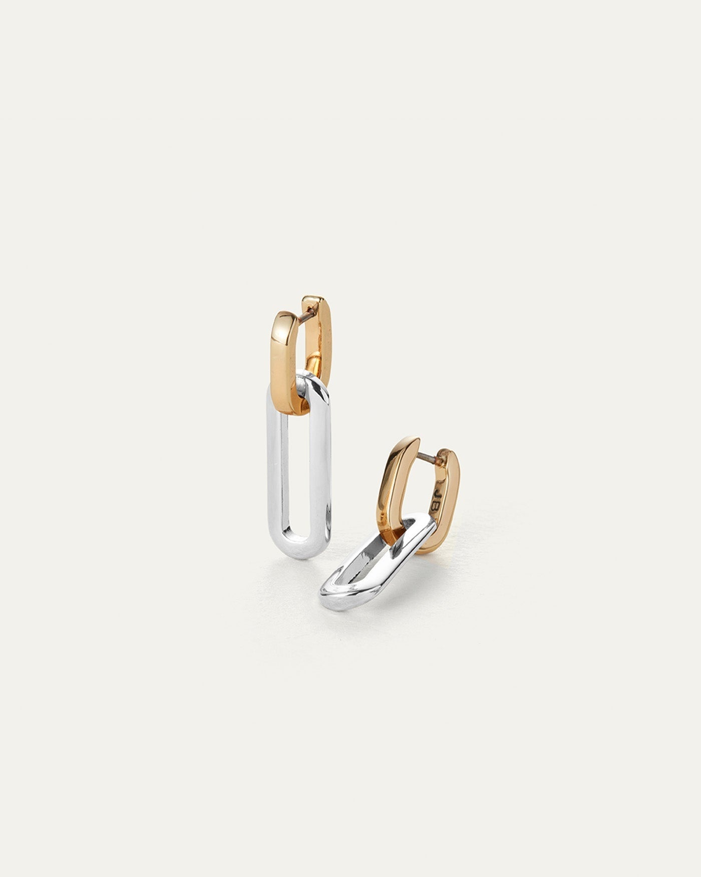 This image features a pair of sophisticated Teeni Detachable Link Earrings. Each earring consists of a gold-tone dipped brass huggie hoop attached to a silver-tone dipped brass detachable link.